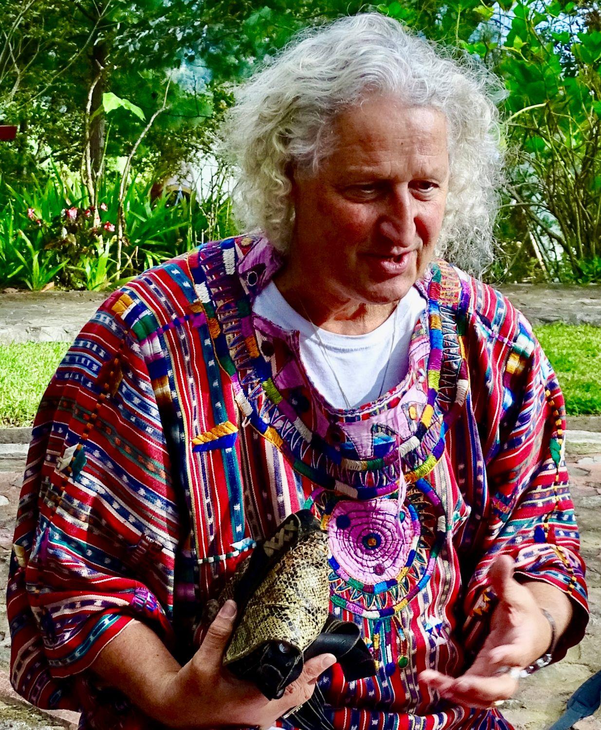 Omrael Norbert Muigg im gewebten Maya-Gewand, im Garten erzählend