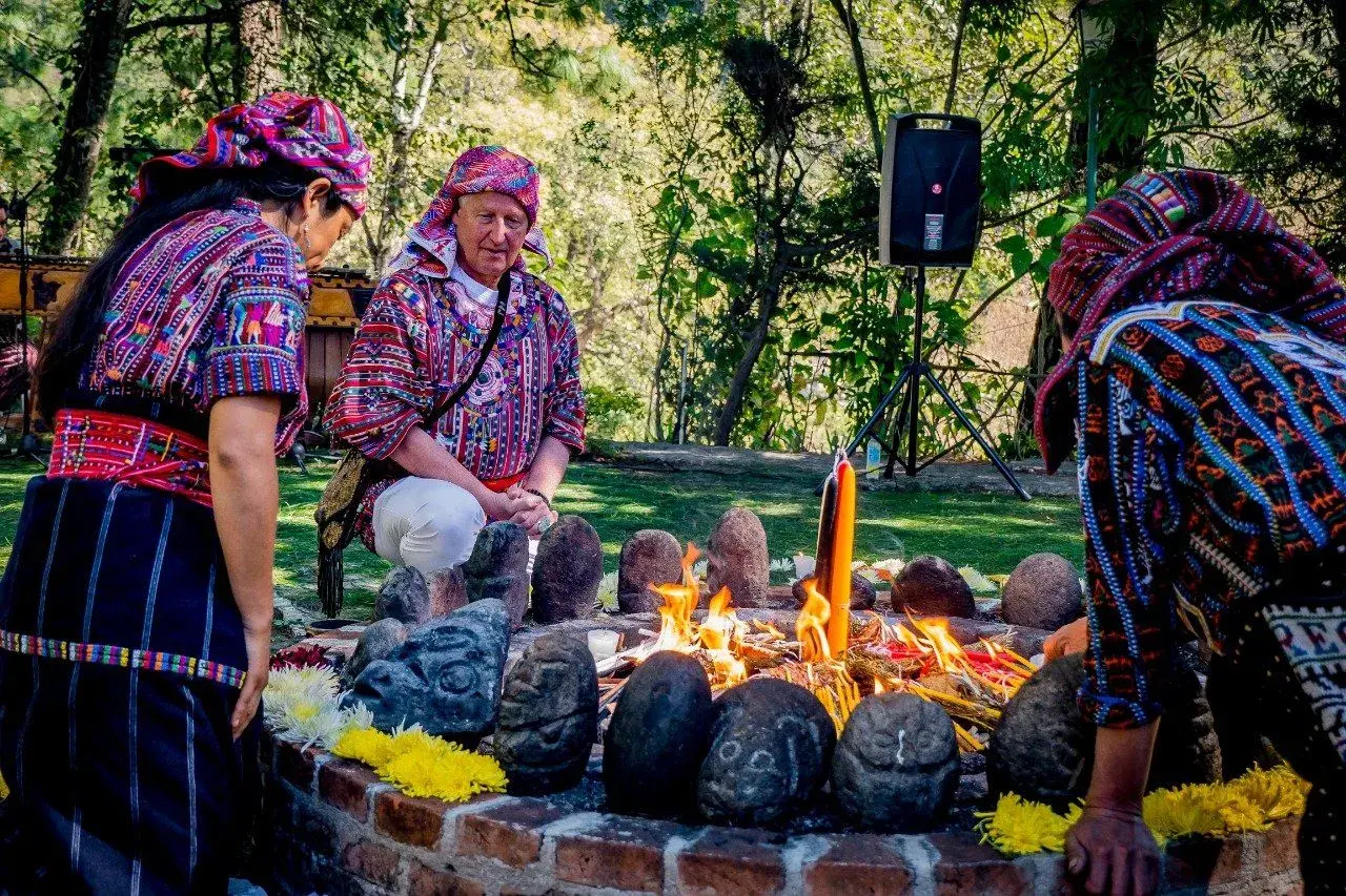 Maya-Schamaninnen in Tracht bei einer Feuerzeremonie im Garten des Zentrums